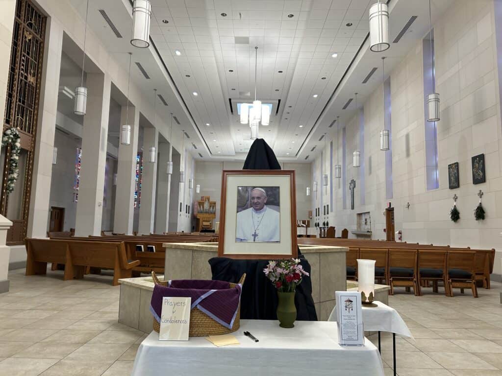 A picture of Pope Francis in front of the baptismal font in the chapel