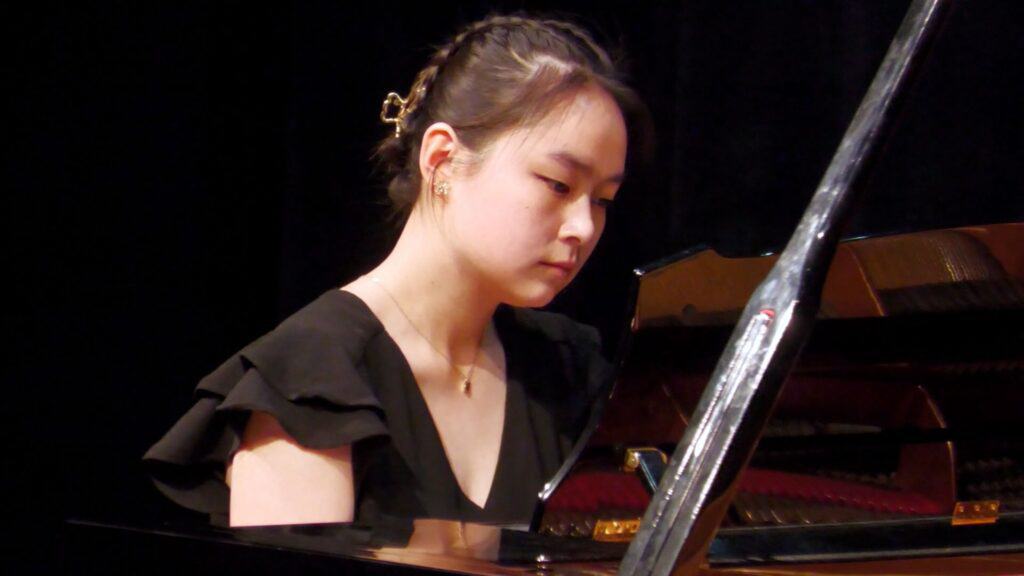 Asian student playing concert piano.