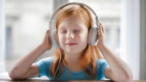 A young girl with headphones on her head.