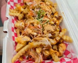 A container of food with chicken and fries.