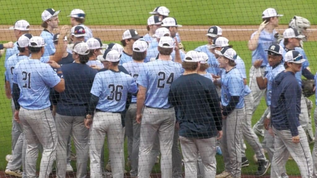 Baseball team celebrating on the field during a game at SAU - The HIVE.
