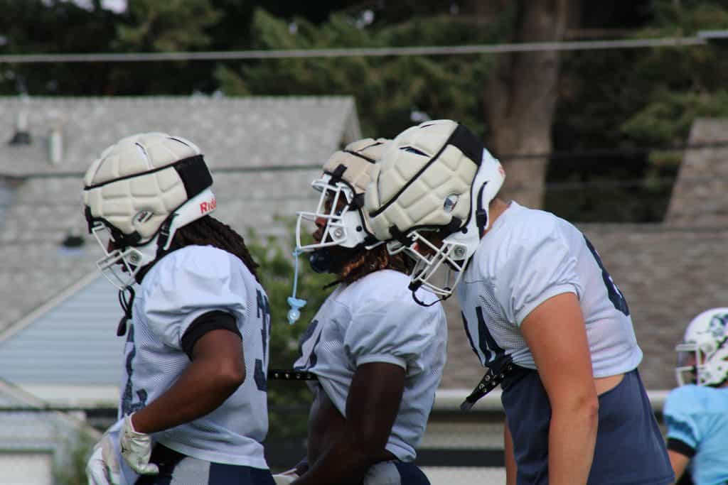 St. Ambrose football players in helmets during practice or game.