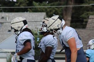 St. Ambrose football players in helmets during practice or game.