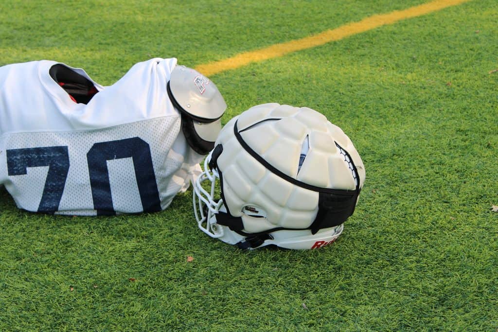 Football helmet and gear on a grassy field for safety and protection.