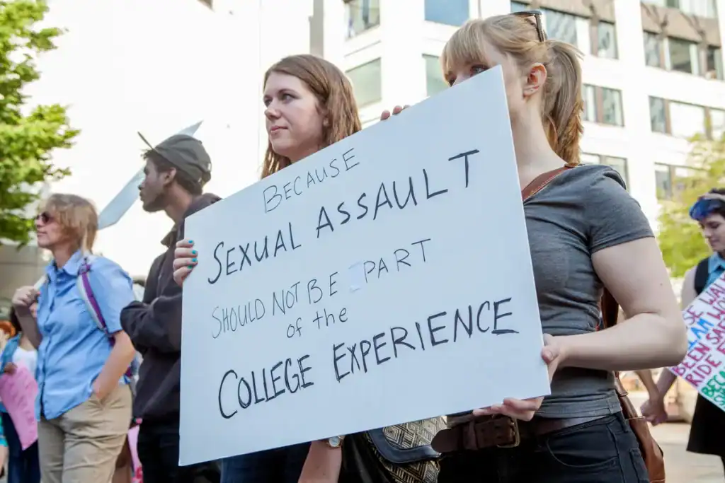 Students protest sign reading 'Because Sexual Assault Should Not Be Part of the College Experience'.